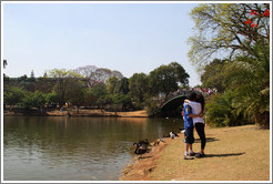 Couple kissing by a lake.  Parque do Ibirapuera.