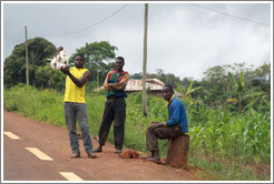 Three men selling goods at the side of the road, near the town of Bangangt