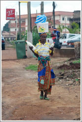 Woman with a bucket on her head and bottles in her hands.