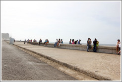People sitting on the wall on the Malec&oacute;n.