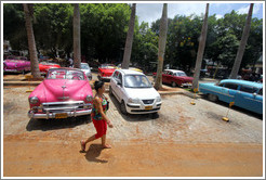 Woman walking past a hot pink car, Paseo del Prado.