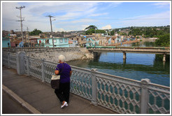 Lady crossing bridge over Rio Yumuri.