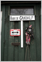 Door with sign saying "Hvor er Gandalf?" ("Where is Gandalf?"), another saying "langt ude" ("long way"), a doll in a gas mask, and a 3rd sign saying "Please do not attempt to walk on the water".