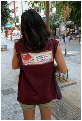Girl wearing a shirt for the Communist Youth of Greece. It says "&#928;&#961;&#969;&#964;&#959;&#960;&#972;&#961;&#945; &#952;&#949;&#969;&#961;&#943;&#945; &#928;&#961;&#969;&#964;&#959;&#960;&#972;&#961;&#945; &#948;&#961;&#940;&#963;&#951; &#947;&#953;&#945; &#964;&#959; &#956;&#941;&#955;&#955;&#959;&#957; &#956;&#945;&#962; &#964;&#959; &#963;&#959;&#963;&#953;&#945;&#955;&#953;&#963;&#956;&#972;," which translates as "Pioneering theory Pioneering action for our future socialism.