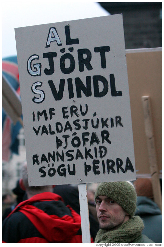 Protest in Reykjavik.  The sign says "Al gj?rt svindl IMF eru valdasj?kir ?j? rannsaki?gu ?eirra" ("Complete swindle; the IMF are power-greedy thieves, read up on their history").