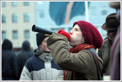 Reykjavik protest.  Woman blowing forn.