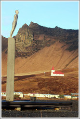 F?r (Voyage), a sculpture by Steinunn ?rarinsd?r (2006), with Vikurkirkja (Church of Vik) visible behind it.