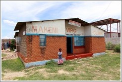 Makeni Viro Clinic, with a girl standing in front.  Garden District.